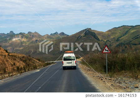 Tourist Van on the highway with traffic sign and mountain backgr Tourist Van on the highway with traffic sign and mountain backgr 16174153