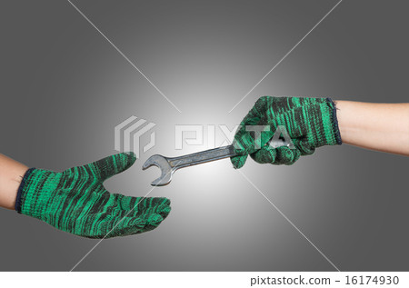 hand holding and sending the wrench on gray background. industri hand holding and sending the wrench on gray background. industri 16174930