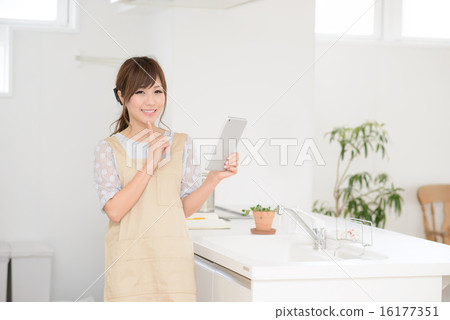 Girls using the iPad in the kitchen Girls using the iPad in the kitchen 16177351