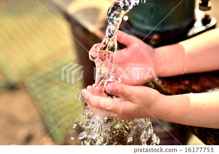 A child washing hands in well water 16177753