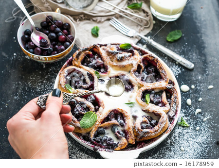 Blueberry buns with fresh mint and creamy sauce on dark backdrop 16178959