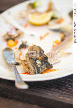 Plate with leftover bones of fish 16194118