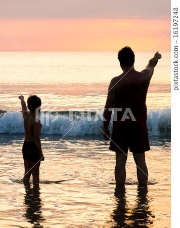 Father and son in front of evening sky seaside Father and son in front of evening sky seaside 16197248