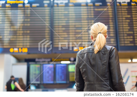 Female traveller checking flight departures board. Female traveller checking flight departures board. 16208174
