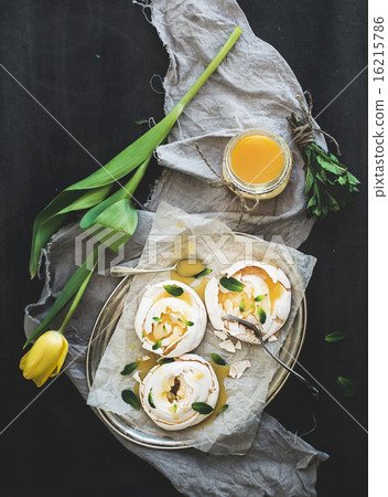 Merengues with lemon curd, fresh mint on silver tray, beige kitchen towel and grunge dark backdrop 16215786
