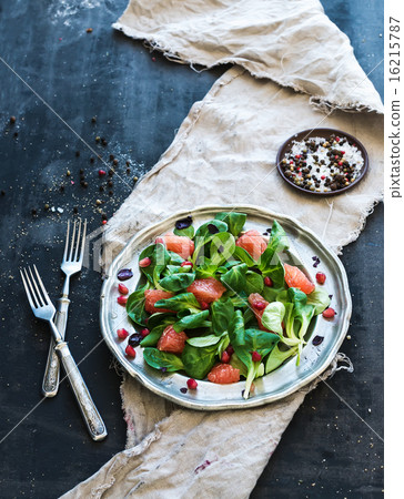 Spring salad with lamb's lettuce, grapefruit, garnet, walnuts and olive oil in vintage metal plate 16215787