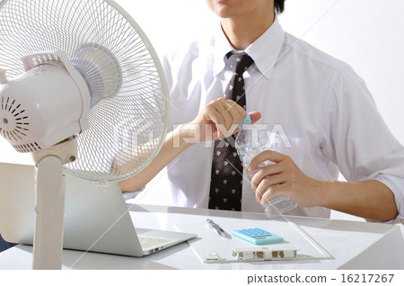 A businessman who works while hanging a fan in a hot summer office 16217267