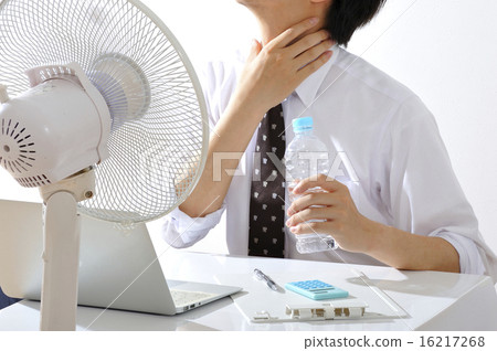 A businessman who works while hanging a fan in a hot summer office 16217268
