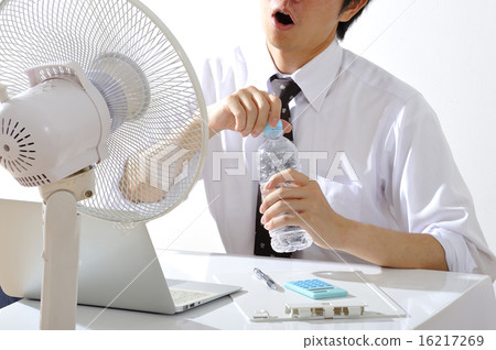A businessman who works while hanging a fan in a hot summer office A businessman who works while hanging a fan in a hot summer office 16217269