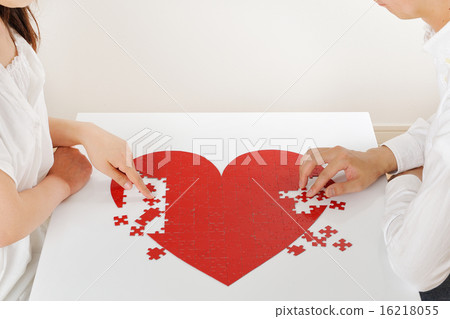 A couple assembling heart puzzles together A couple assembling heart puzzles together 16218055