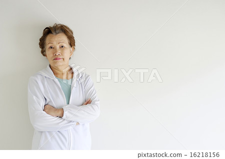 An elderly woman looking at the camera with his arms folded 16218156