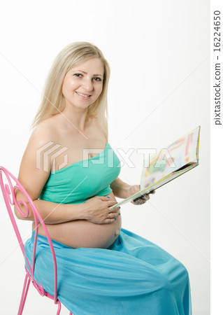 pregnant young woman sitting on chair and reading a book pregnant young woman sitting on chair and reading a book 16224650
