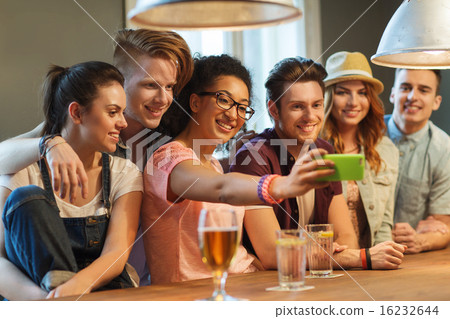 happy friends with smartphone taking selfie at bar 16232644