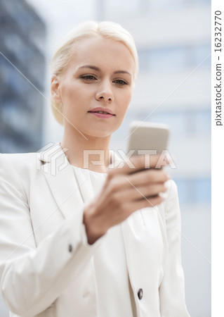 serious businesswoman with smartphone outdoors 16232770