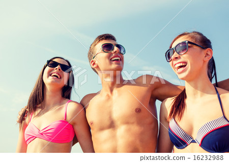 smiling friends in sunglasses on summer beach smiling friends in sunglasses on summer beach 16232988