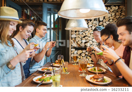 happy friends with smartphones picturing food 16233211