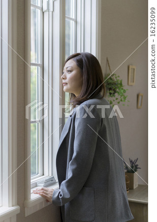 A woman looking out the window 16235099