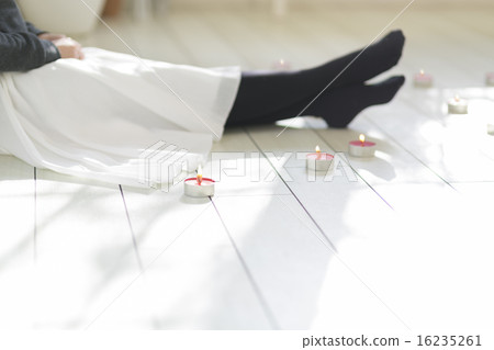 一個女人坐在蠟燭放置的地板上 16235261