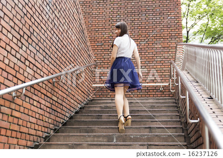 Young lady rising stairs Ascending back looking back Young lady rising stairs Ascending back looking back 16237126
