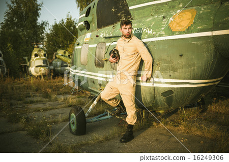 Young pilot posing near the helicopter 16249306
