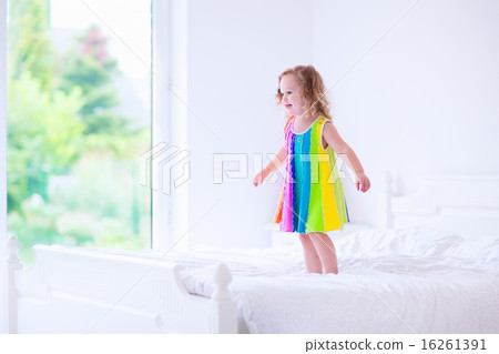 Little girl jumping on a bed 16261391