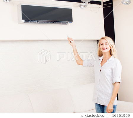 Female holding a remote control air conditioner 16261969