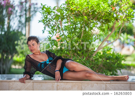 young woman laying down on stone bench 16263803