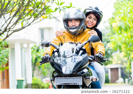 Couple with helmets riding motorcycle 16271122