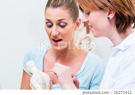 Alternative practitioner explaining acupuncture 16271412
