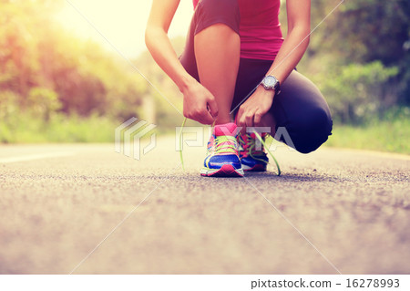 young asian woman tying shoelace young asian woman tying shoelace 16278993