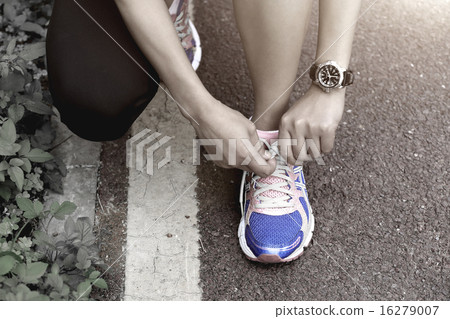 young asian woman tying shoelace   16279007