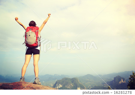 cheering woman hiker open arms at mountain peak 16281278