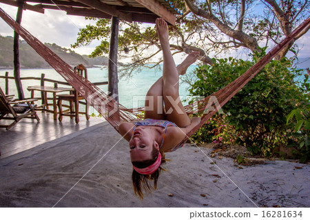 Woman posing at romantic hammock in private house near tropical beach Woman posing at romantic hammock in private house near tropical beach 16281634