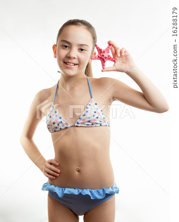 smiling girl in swimsuit holding red starfish 16288179