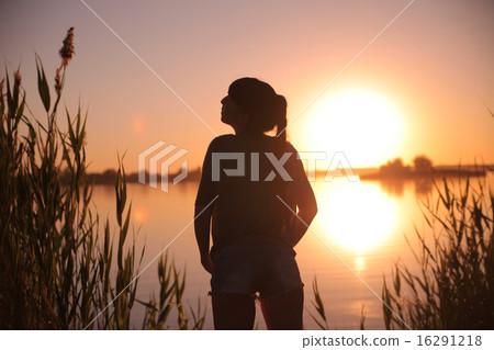 Girl at the lake at sunset 16291218