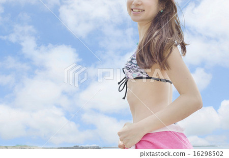 站立在海灘的游泳衣的一位小姐 站立在海灘的游泳衣的一位小姐 16298502