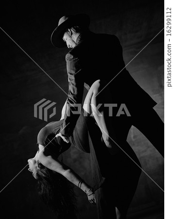 Man and woman dancing, concrete building surroundings 16299112