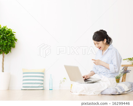 A woman using a personal computer in a room A woman using a personal computer in a room 16299446