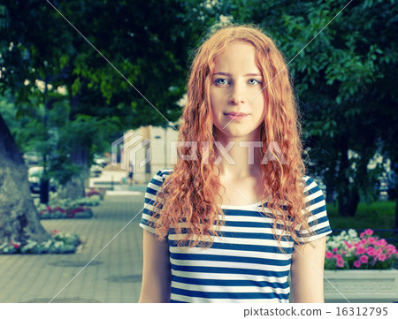 Ginger haired women feeling unhappy and looking at camera. 16312795