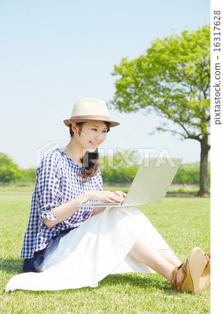 A woman using a laptop computer outside A woman using a laptop computer outside 16317628