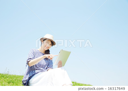 A woman using a tablet outside 16317649