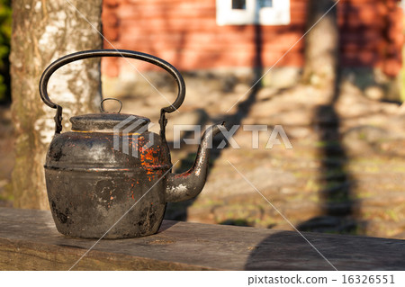 Old kettle in wooden bench outdoors Old kettle in wooden bench outdoors 16326551