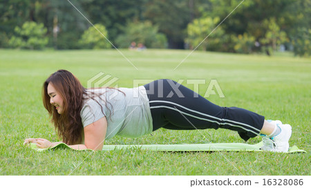 Obese woman doing plank on the grass. 16328086