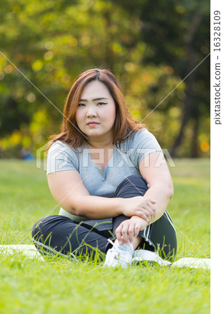Obese woman relaxing on the grass. 16328109
