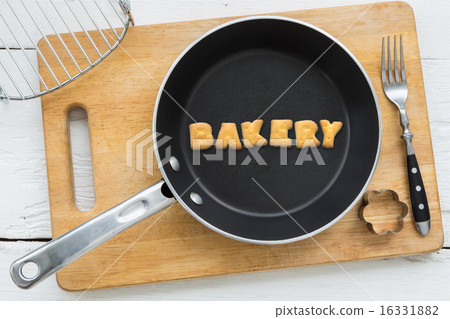 Alphabet crackers word BAKERY putting in pan 16331882