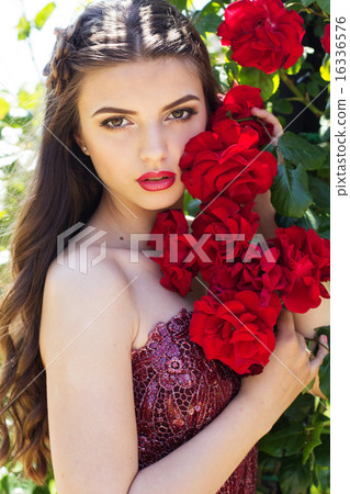 Fashion portrait of beautiful woman is posing near roses Fashion portrait of beautiful woman is posing near roses 16336576
