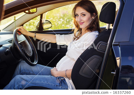 Pregnant happy young woman is sitting in black car Pregnant happy young woman is sitting in black car 16337260