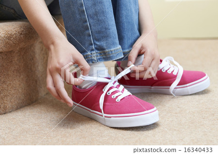 Girl Sitting On Stairs And Tying Shoelaces Girl Sitting On Stairs And Tying Shoelaces 16340433