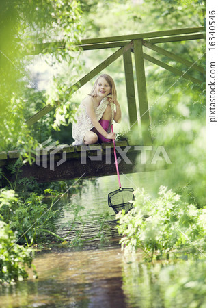 Young Girl Catching Fish With Net From Wooden Bridge Young Girl Catching Fish With Net From Wooden Bridge 16340546