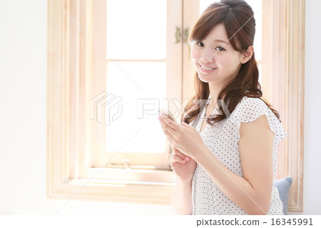 A woman relaxing at the window A woman relaxing at the window 16345991
